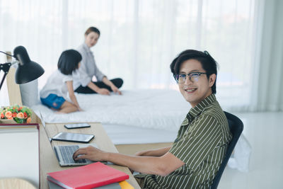 Portrait of smiling young woman using smart phone on table