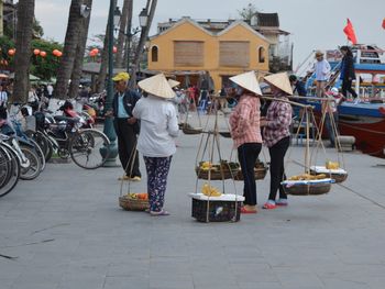 People selling fruits on street in city