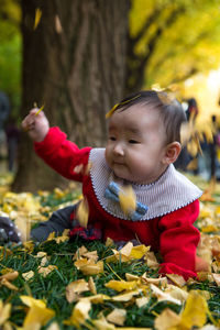 Close-up of baby girl playing with leaves on field