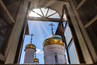 Low angle view of bell tower amidst buildings against sky