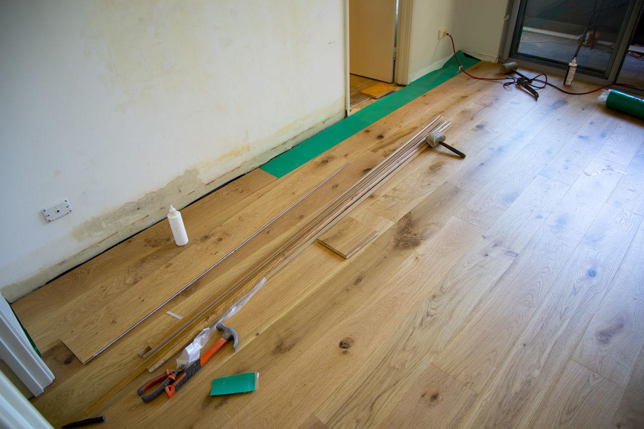 HIGH ANGLE VIEW OF EMPTY HARDWOOD FLOOR AGAINST WALL