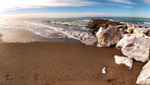 Rocks on beach against sky