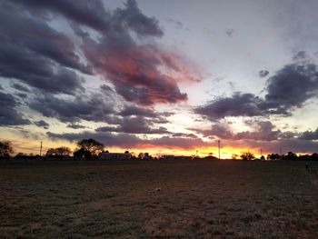 Scenic view of dramatic sky over land during sunset