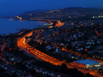 Aerial view of illuminated cityscape against sky at night