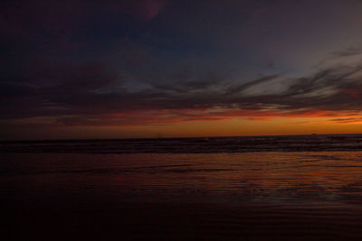 Scenic view of sea against dramatic sky during sunset