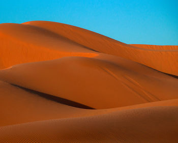 Scenic view of desert against clear blue sky