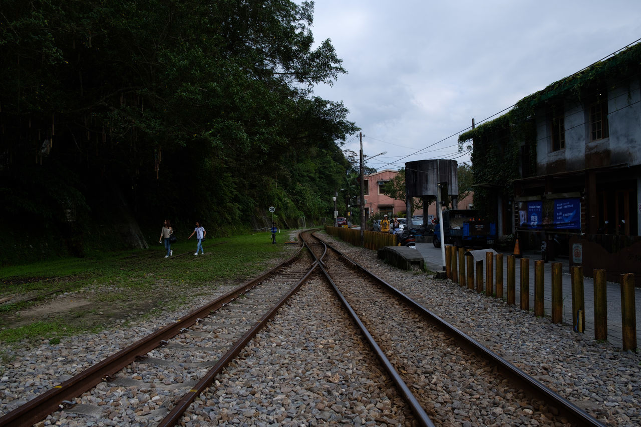 RAILROAD TRACK BY TREES AGAINST SKY