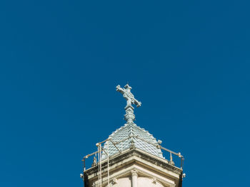 Low angle view of statue of building against blue sky