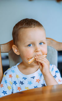 Close-up of cute girl eating food at home