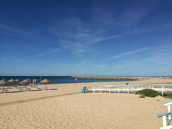 Scenic view of beach against blue sky