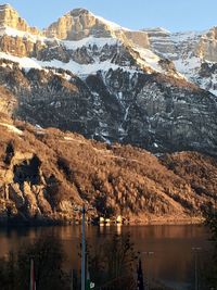 Scenic view of lake by mountains against sky