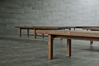 Empty bench on table against wall