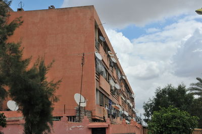 Low angle view of buildings against cloudy sky