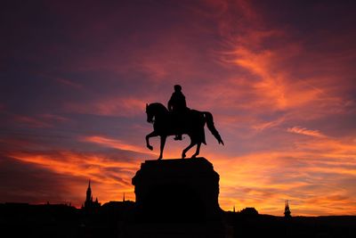 Low angle view of silhouette statue against sunset sky