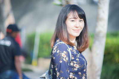 Portrait of smiling woman standing outdoors