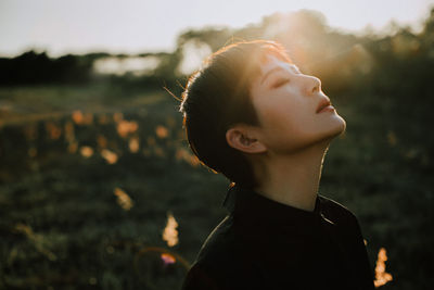 Close-up of woman with eyes closed against sky