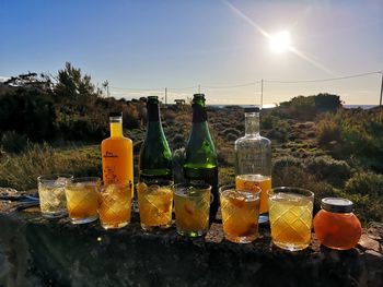 Wine bottles on table against sky