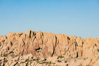 Low angle view of rock formations against clear blue sky