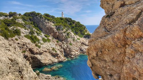 Rock formations by sea against sky