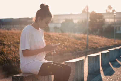 Side view of woman sitting on steps