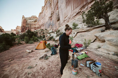 Female hiker prepares dinner while remote camping in the maze utah