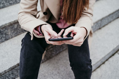 Midsection of woman using mobile phone