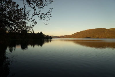 Scenic view of lake against clear sky during sunset