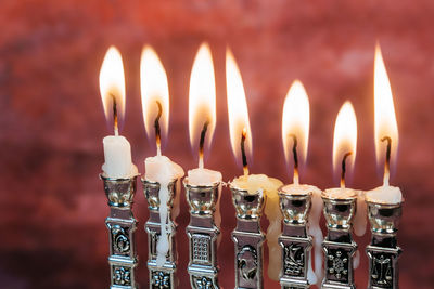 Close-up of illuminated candles against wall