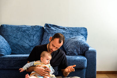 Father and son on sofa at home