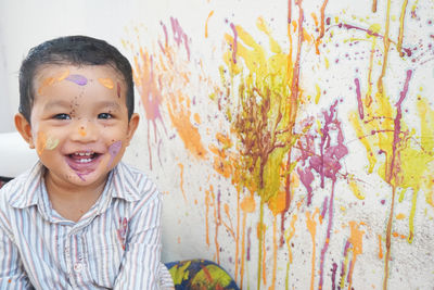 Portrait of smiling boy against wall