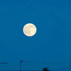 Low angle view of moon against blue sky