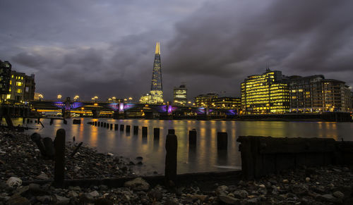 Illuminated shard building against cloudy sky