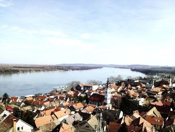 High angle view of townscape by river against sky