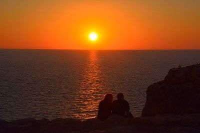 Scenic view of sea against orange sky