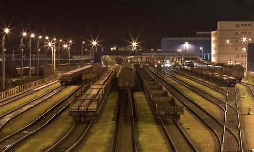 High angle view of trains on illuminated tracks at night