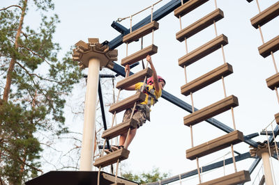 Low angle view of workers working against clear sky