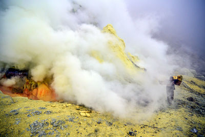 High angle view of senior man walking by hot spring on mountain