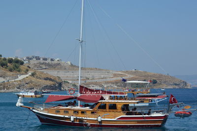 Sailboats moored on sea against clear sky