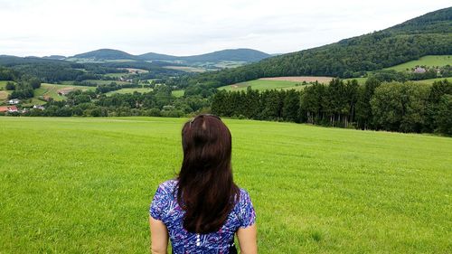 Rear view of woman on field against sky