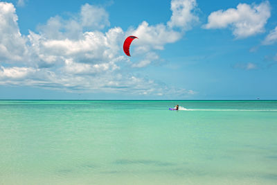Rear view of person paragliding over sea against sky