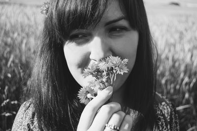 Close-up of woman looking away while smelling flowers