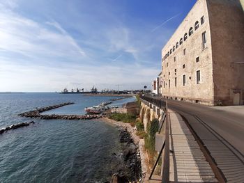 Panoramic view of sea and buildings against blue sky