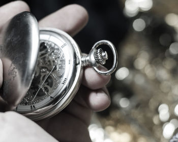 Cropped hand holding pocket watch