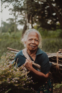 Portrait of young woman standing in forest