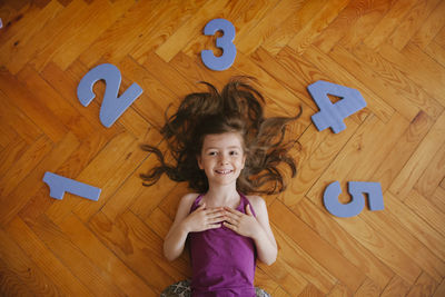Portrait of a smiling girl standing on hardwood floor