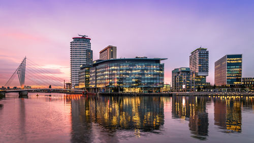 Reflection of buildings in city at waterfront