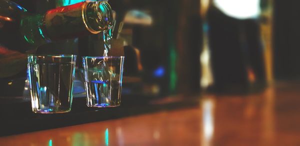 Close-up of alcoholic drink being poured in glass on table