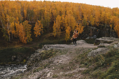 Happy people in love are travel hike in nature in the autumn forest. romantic trip to countryside