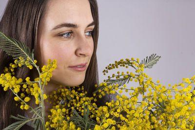 Close-up portrait of woman against yellow flowering plants
