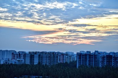 Buildings in city against sky during sunset